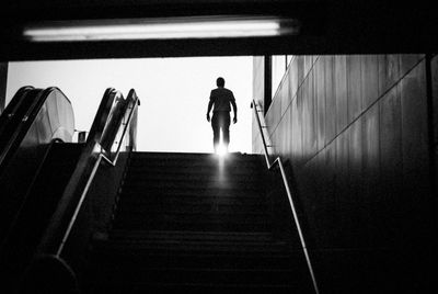 Rear view of man standing by staircase against sky