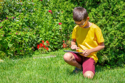 Rear view of boy sitting on grass