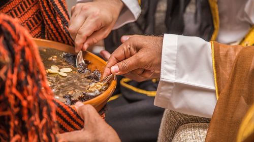 Cropped hands of men having food in bowl