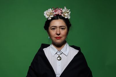 Portrait of woman standing against blue background