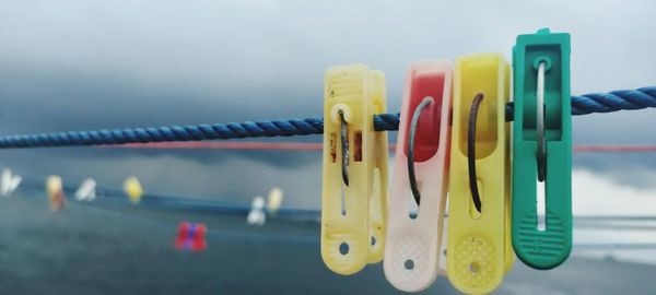 Close-up of clothespins hanging on rope