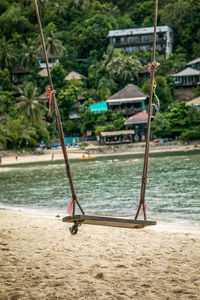 Swing at beach against sky