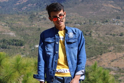 Portrait of young man wearing sunglasses standing outdoors