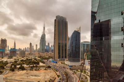 Modern buildings in city against cloudy sky