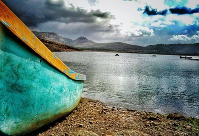 Close-up of boat moored in sea against sky