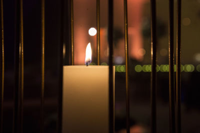 Close-up of illuminated candle in darkroom