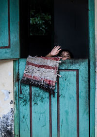 Woman relaxing on window of abandoned house