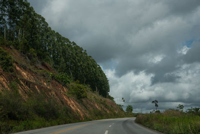 Road amidst trees against sky