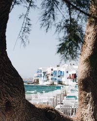 Scenic view of sea by buildings against sky