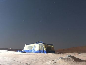 Tent on beach by sea against sky