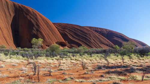 Rock formations on landscape against clear blue sky