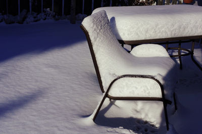 Empty chair on snow covered field