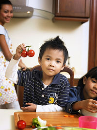 Portrait of boy with sister and mother in kitchen