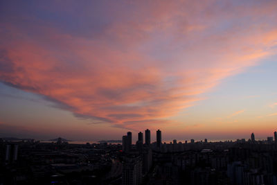 Modern buildings against sky during sunset