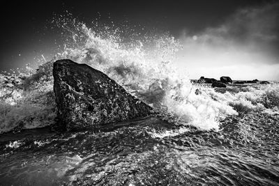 Waves splashing on rocks against sea