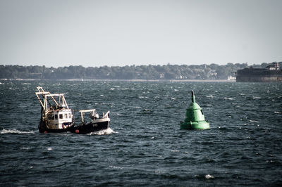 Ship sailing in sea against clear sky