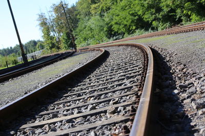 Railroad tracks by trees against sky