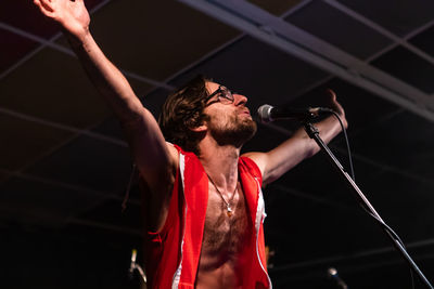 Low angle view of man singing song at stage