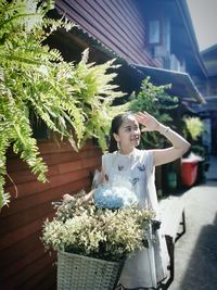 Woman with flower bouquet against building