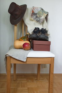 Hat, scarf,sweater, shoes and organic pumpkin on wooden chair