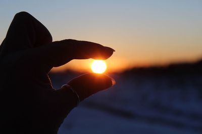 Optical illusion of hand holding sun