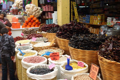 Rear view of boy standing by grains for sale