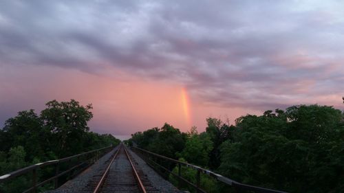 Railroad tracks against cloudy sky