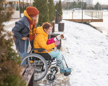 Rear view of woman sitting on snow