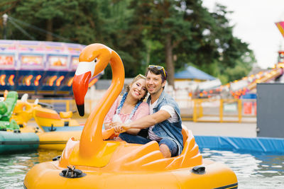 Happy couple in love riding a water ride in an amusement park