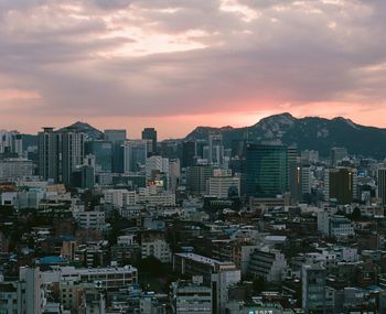 Aerial view of buildings in city against sky during sunset