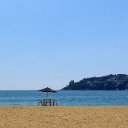 Scenic view of beach against clear blue sky