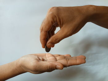 Close-up of hand holding hands against white background