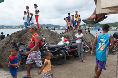 People at beach against sky