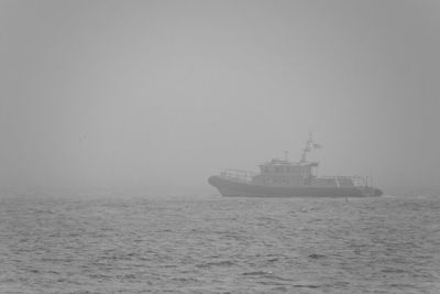 Ship sailing in sea against sky