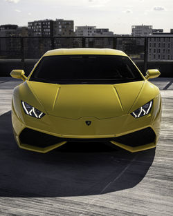 Close-up of yellow car on road