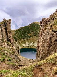 Scenic view of rocks by lake against sky