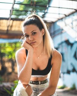 Portrait of beautiful woman standing against blurred background