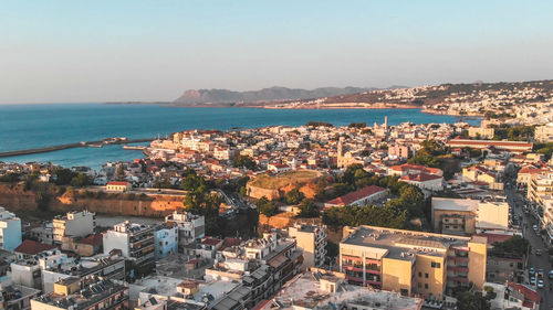 High angle view of townscape by sea against sky