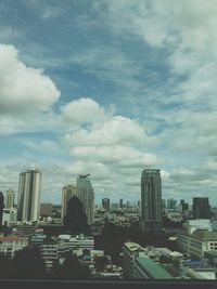 View of cityscape against cloudy sky