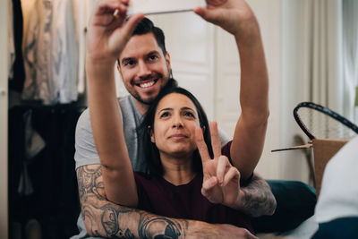 Loving couple taking selfie on mobile phone in bedroom