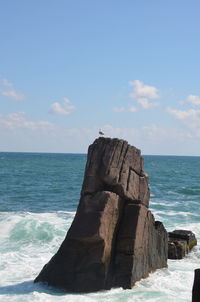 Scenic view of rocks on beach against sky