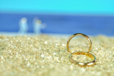 Close-up of wedding rings on sand