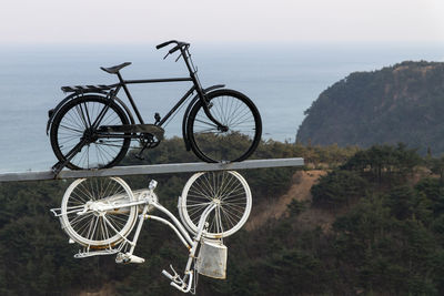 Bicycle by sea against sky