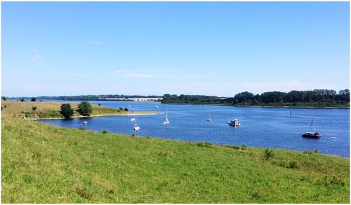 Scenic view of lake against clear blue sky