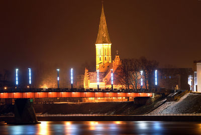 Illuminated buildings in city against sky at night