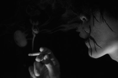 Close-up of woman hand against black background