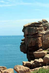 Rocks on sea shore against sky