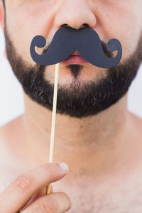 Close-up of man holding prop with mustache