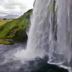 Scenic view of waterfall against sky