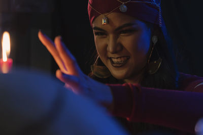 Female fortune teller with burning candles at home